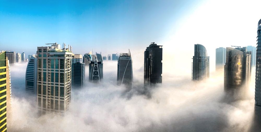Panoramic view of skyscrapers above the clouds