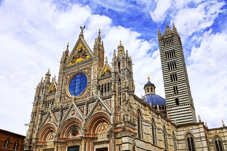 Low angle view of siena cathedral against sky in city
