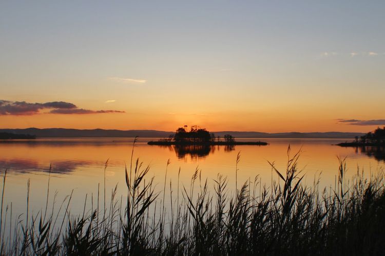 Scenic view of lake against sky during sunset