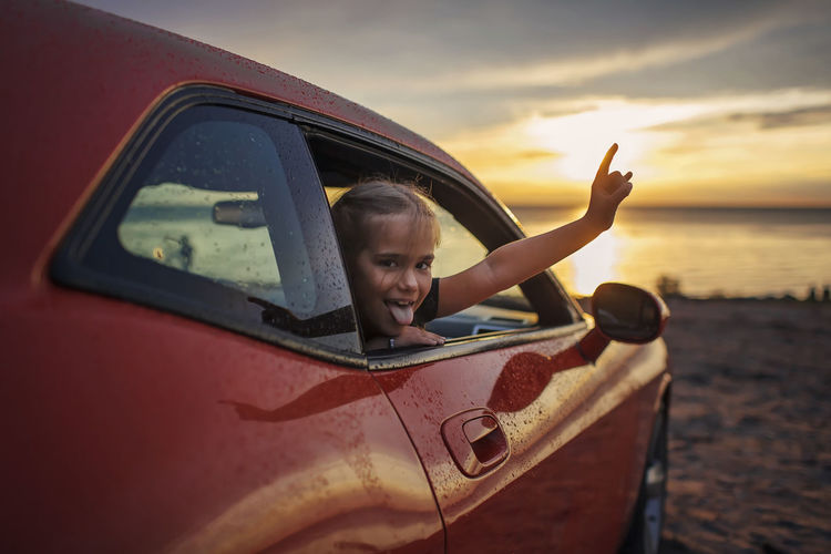 Portrait of girl looking through car window