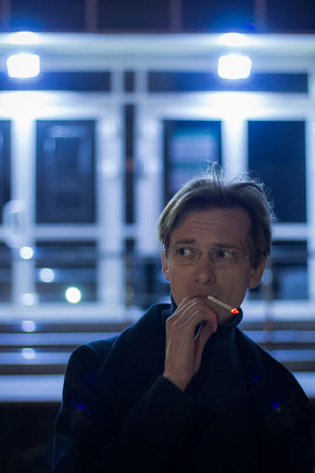 Portrait of man smoking at night