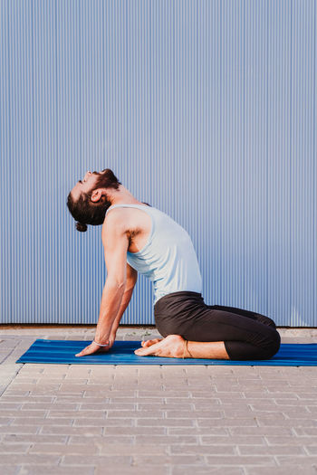 Side view of man doing yoga