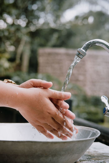 Cropped hand of woman holding water fountain