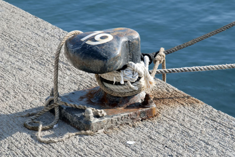 Rope tied to wooden post on pier