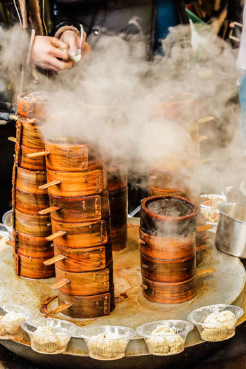 Hand preparing chinese steamed food in bamboo steamers