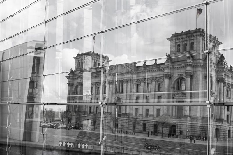 Low angle view of glass building against sky