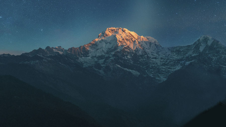 Scenic view of machapuchare snowcapped mountains against sky at sunrise