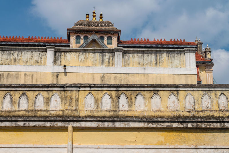 Low angle view of exterior wall of mysore palace at mysuru, karnataka, india against sky