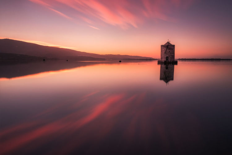 Scenic view of lake against sky during sunset