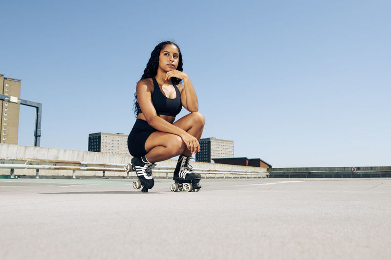 Young woman wearing roller skates, urban background.