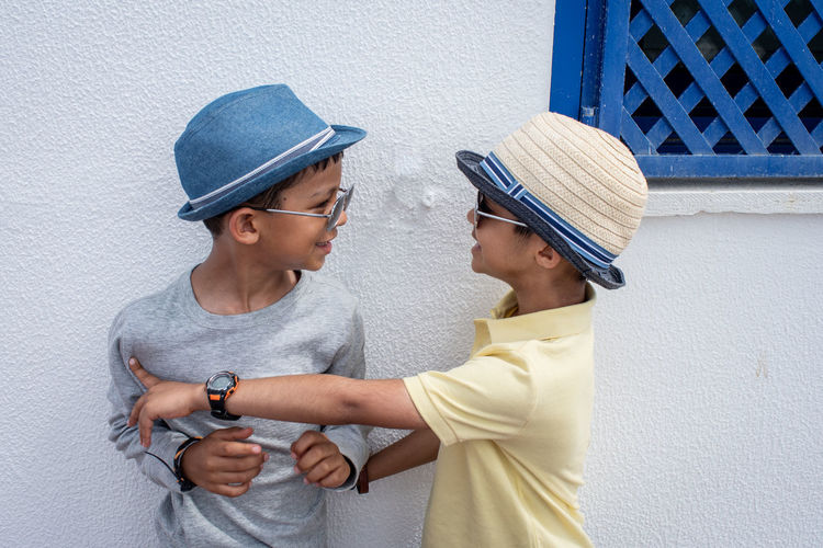 Siblings talking while standing by house