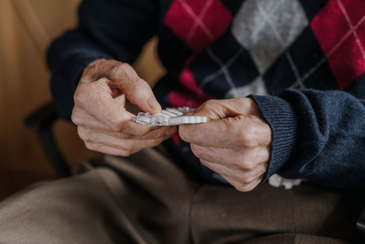 Midsection of senior man holding medicines