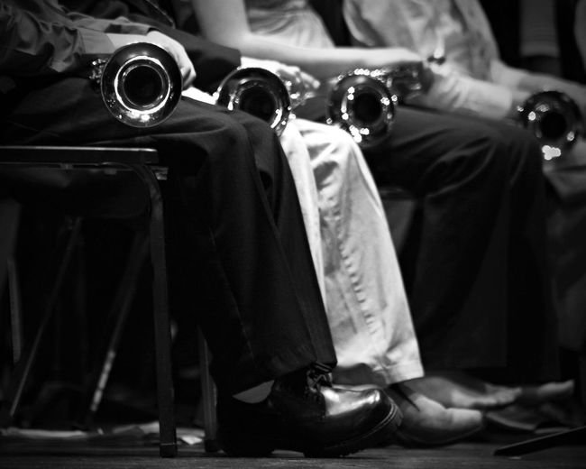 Low section of people with trumpets on chair