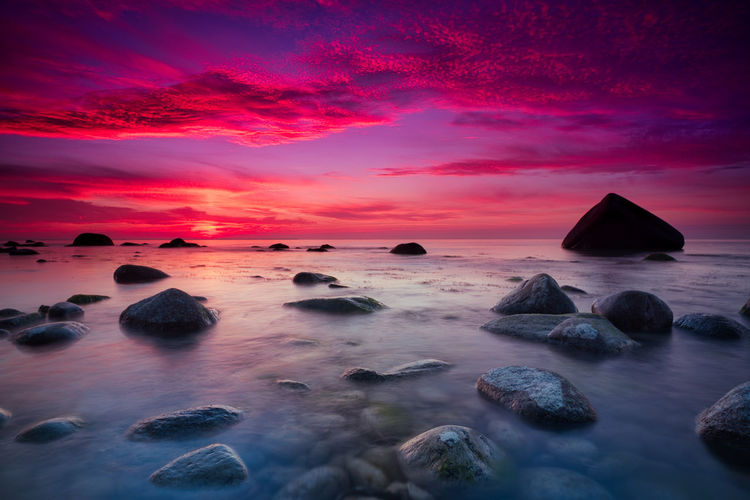 Scenic view of sea against romantic sky at sunset