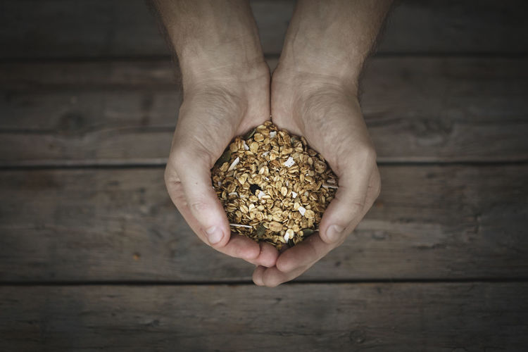 Oat flakes in mans hands, close-up