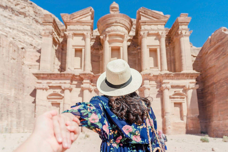 Hand holding woman at historic building