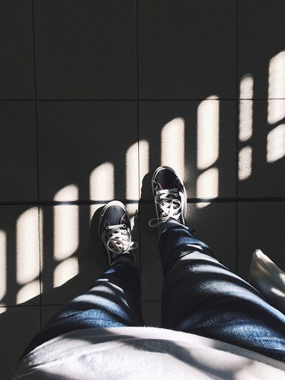Low section of person standing on floor during day