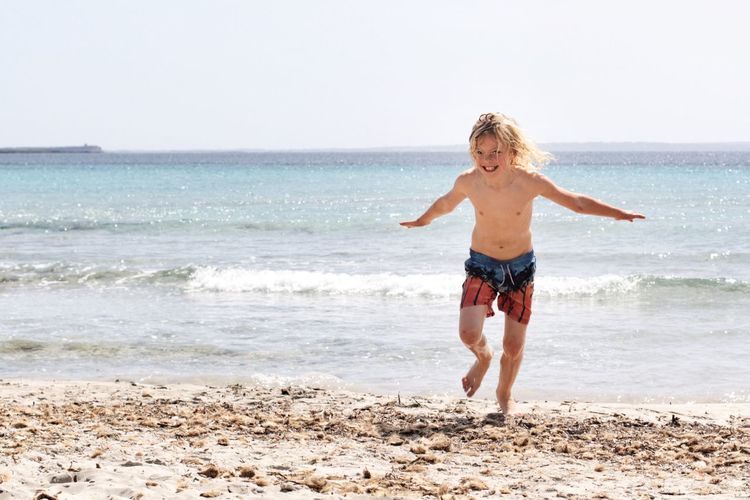 Full length of boy enjoying at beach