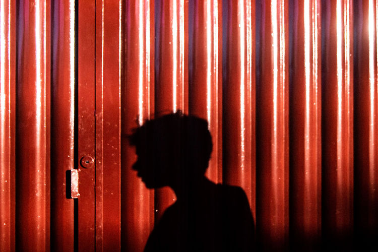 Shadow of man on brown corrugated iron