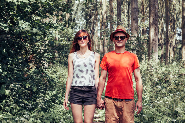 Portrait of smiling couple standing in forest