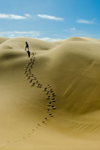 View of man on walking on sand dune