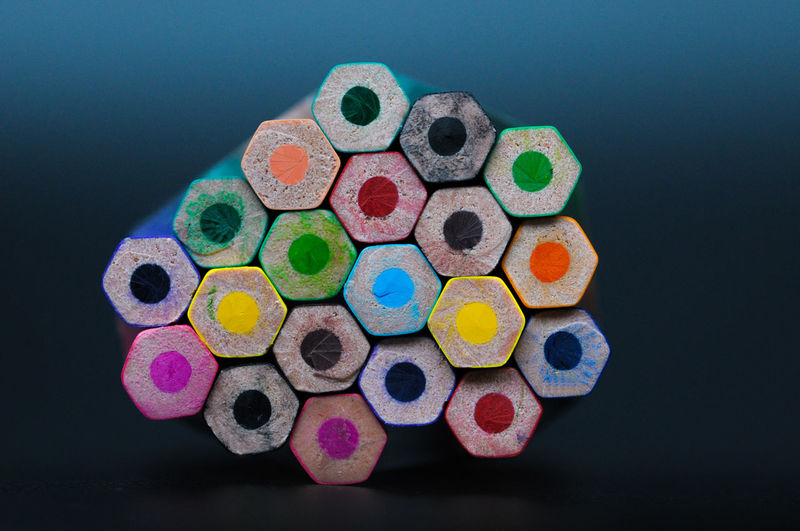 Close-up of multi colored pencils on table against black background