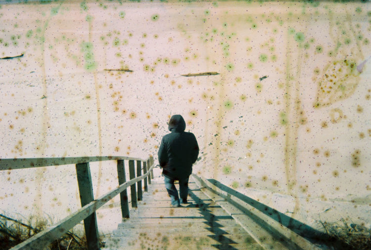 Rear view of man walking on footpath