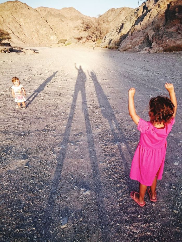 Shadow of family on arid landscape
