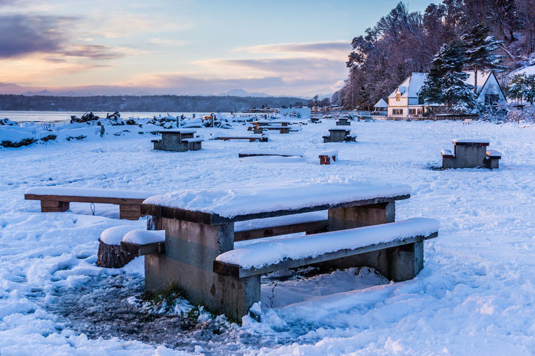 Snow on picnic tables.