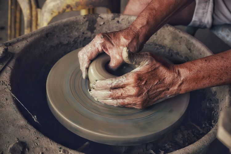 Cropped hands of worker making pottery in workshop