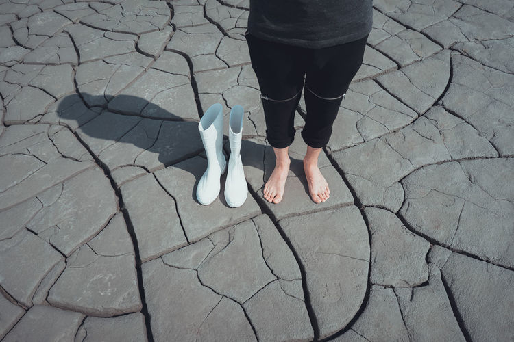Low section of woman standing on cracked ground