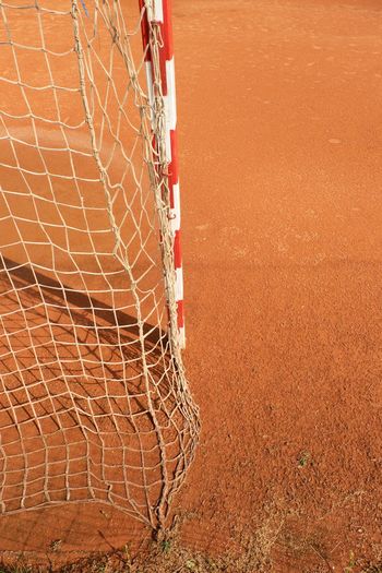 Outdoor football or handball playground, light red clay. red crushed bricks surface