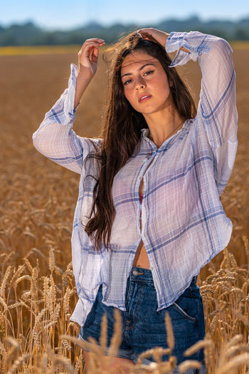 Beautiful young woman standing on field
