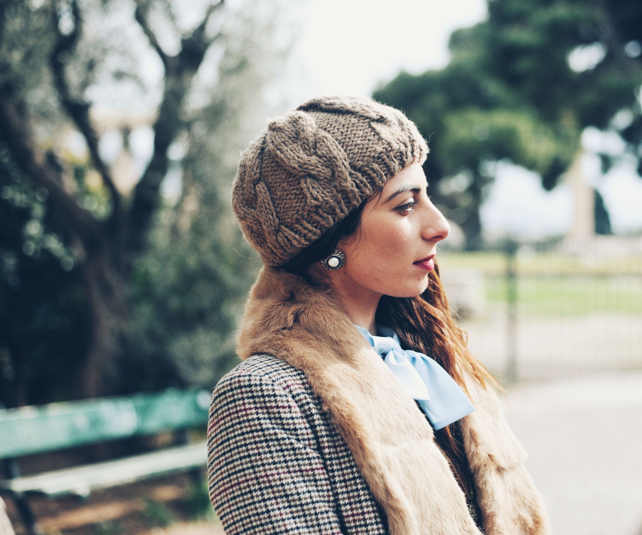 young adult, focus on foreground, one person, leisure activity, real people, young women, lifestyles, hat, clothing, portrait, looking, tree, looking away, women, adult, standing, waist up, day, beautiful woman, contemplation, warm clothing, outdoors, hairstyle, teenager