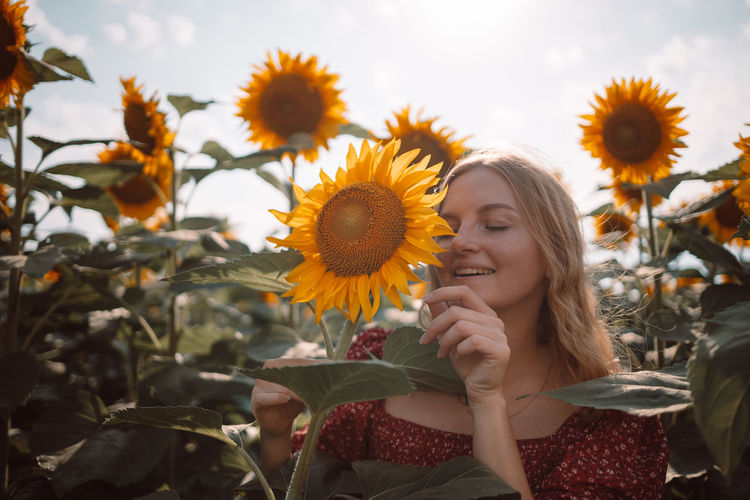 Close-up of woman standing amidst sunflower