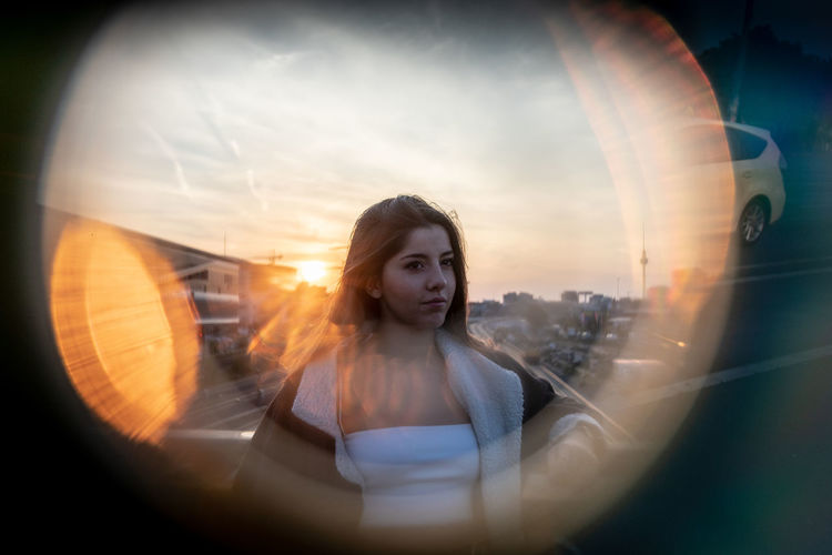 Young woman seen through equipment against sky during sunset