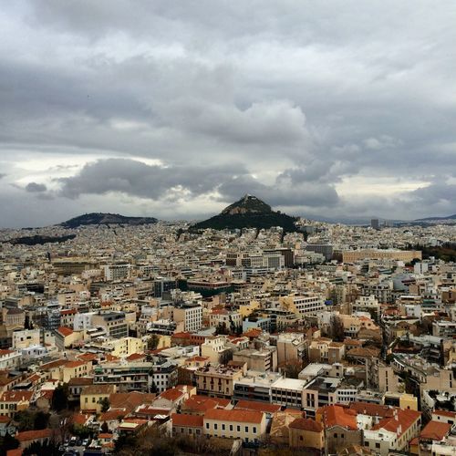 View of cityscape against cloudy sky