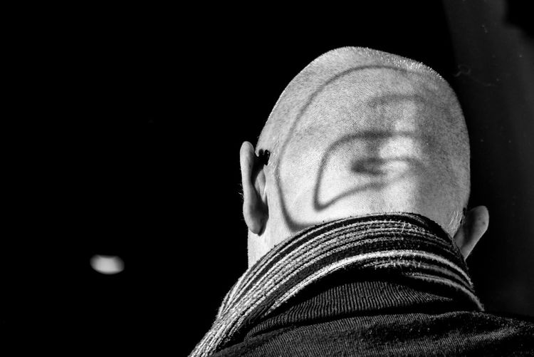 Spiral shadow on shaved head of man at night
