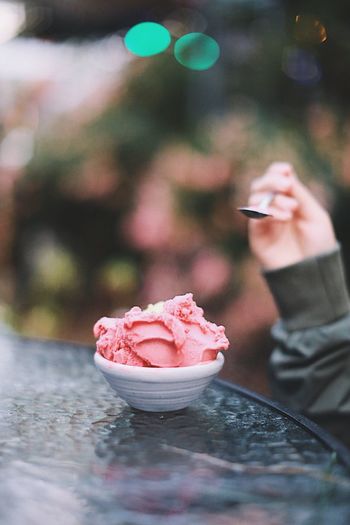 Cropped hand of person eating ice cream at table in garden party