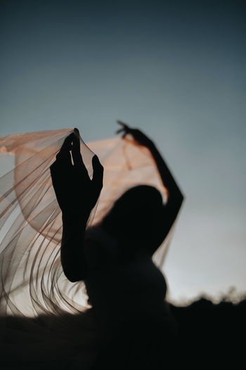 Silhouette woman against sky at sunset