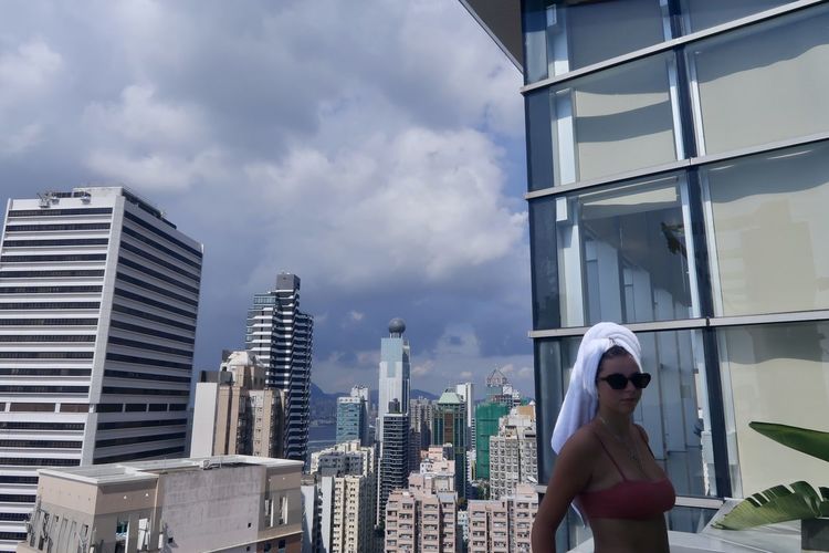Woman standing against modern buildings in city