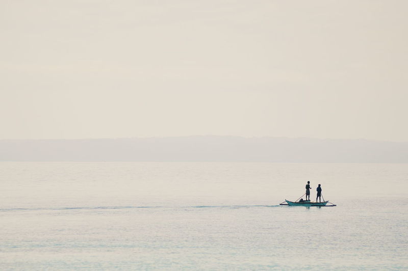 Scenic view of people in boat in sea