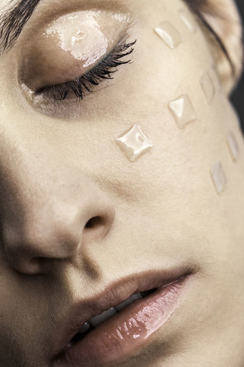 Close-up of young woman with beauty product