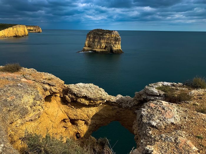 Scenic view of rocks in sea against sky