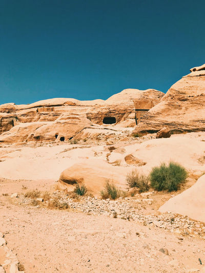 Scenic view of desert rocks against clear blue sky. petra