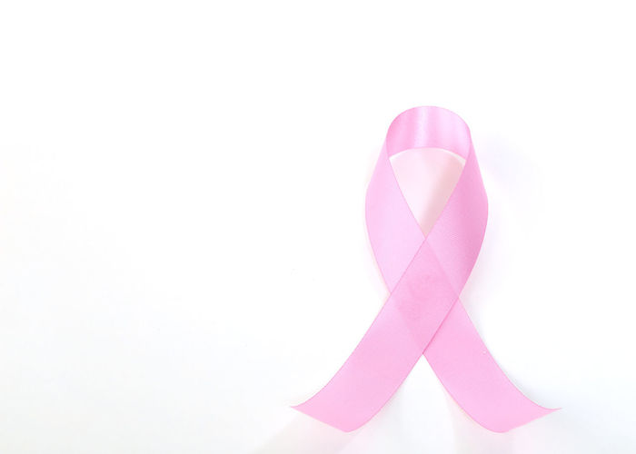 Close-up of pink breast cancer awareness ribbon against white background