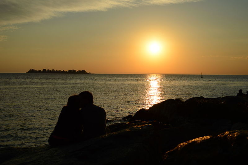 Silhouette couple romancing on beach during sunset
