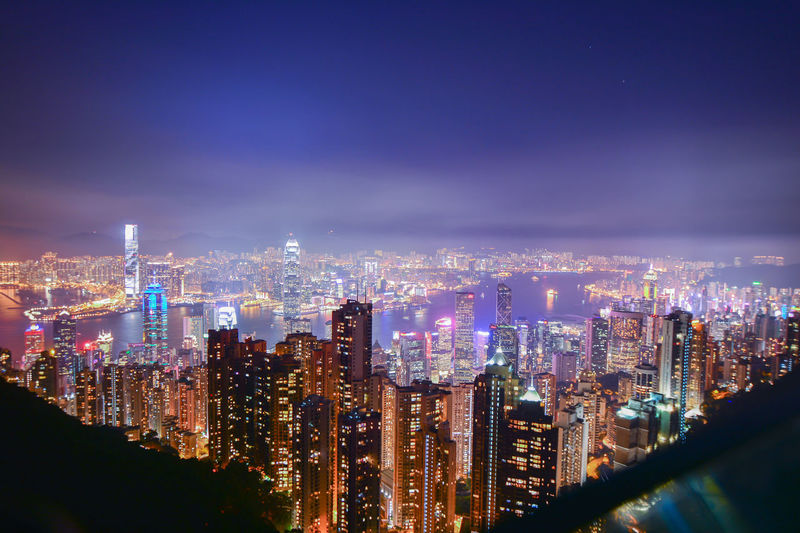 Illuminated cityscape against sky at night