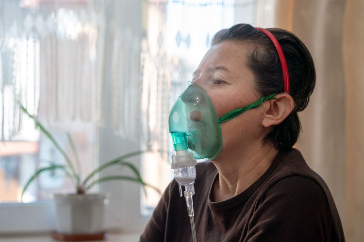 Woman using an inhalation mask at home