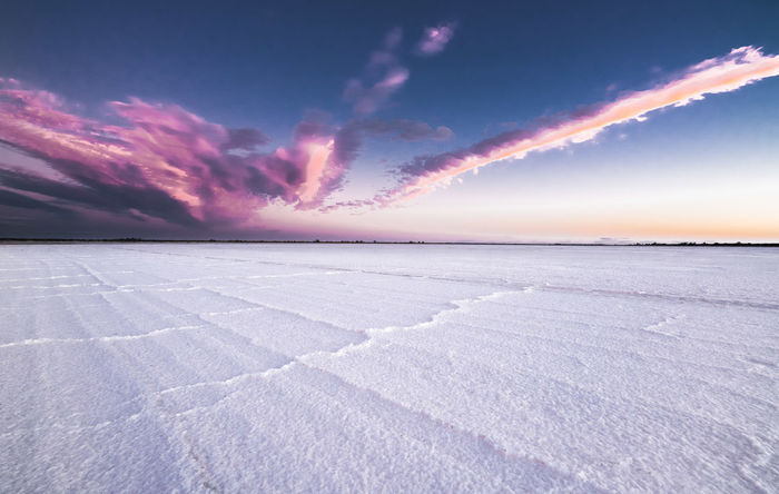 Scenic view of salt lake against sky during sunset
